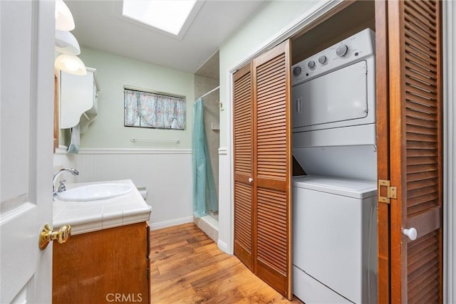 501 Old State Rd, Wofford Heights, CA 93285 - laundry room featuring stacked washer / dryer, wood finished floors, and a wainscoted wall