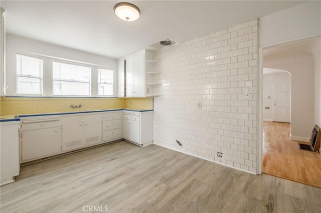 473 W 17th St, San Pedro, CA 90731 - kitchen featuring arched walkways, white cabinetry, light wood finished floors, tile walls, and open shelves