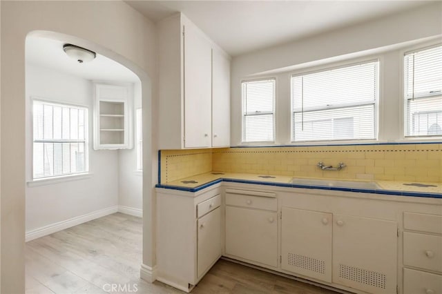 473 W 17th St, San Pedro, CA 90731 - kitchen with tasteful backsplash, arched walkways, light wood-style flooring, and tile counters