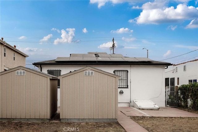 473 W 17th St, San Pedro, CA 90731 - rear view of house with a storage shed and roof mounted solar panels