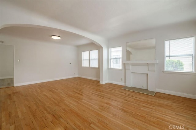 473 W 17th St, San Pedro, CA 90731 - unfurnished living room with arched walkways and light wood-style flooring