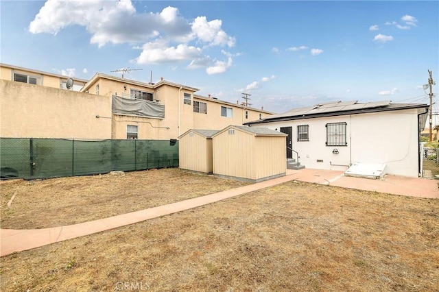 473 W 17th St, San Pedro, CA 90731 - rear view of property with a shed, stucco siding, solar panels, and a fenced backyard