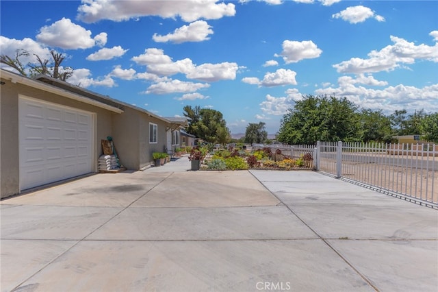 16116 Cajon, Hesperia, CA 92345 - view of side of home featuring driveway, stucco siding, and an attached garage