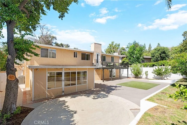 17211 Orozco St, Granada Hills, CA 91344 - rear view of property featuring stucco siding, a patio, and a balcony