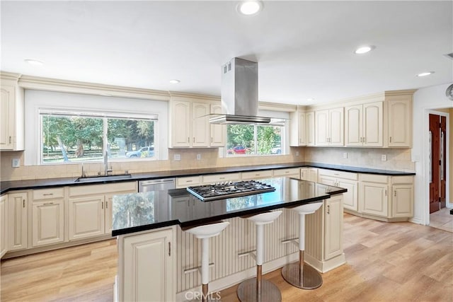 17211 Orozco St, Granada Hills, CA 91344 - kitchen with island exhaust hood, appliances with stainless steel finishes, dark countertops, a kitchen island, and light wood-style floors