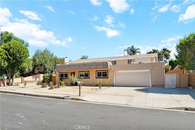17211 Orozco St, Granada Hills, CA 91344 - view of front of home with stucco siding, concrete driveway, a chimney, a gate, and an attached garage