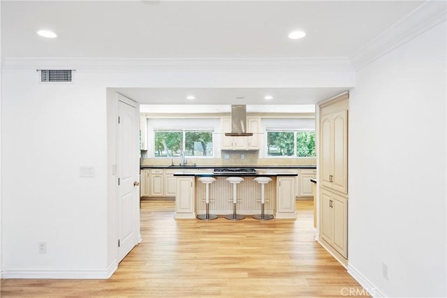 17211 Orozco St, Granada Hills, CA 91344 - kitchen with wall chimney range hood, ornamental molding, a kitchen bar, light wood-style floors, and a center island