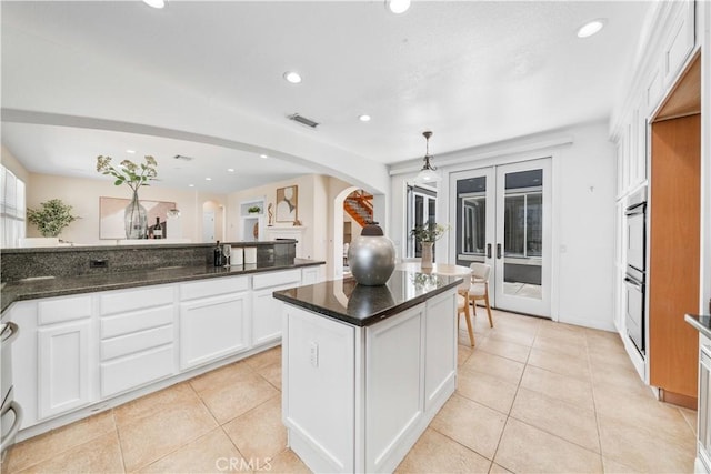 23735 Canyon Vista Ct, Diamond Bar, CA 91765 - kitchen with arched walkways, french doors, white cabinets, recessed lighting, and light tile patterned flooring