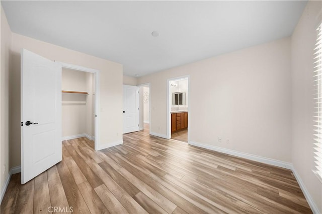 23735 Canyon Vista Ct, Diamond Bar, CA 91765 - unfurnished bedroom with light wood-type flooring, a spacious closet, and connected bathroom