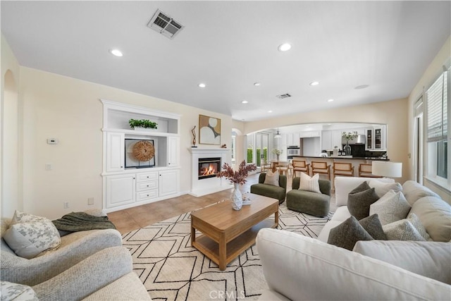 23735 Canyon Vista Ct, Diamond Bar, CA 91765 - living area with arched walkways, recessed lighting, a glass covered fireplace, and light tile patterned floors