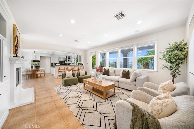 23735 Canyon Vista Ct, Diamond Bar, CA 91765 - living area featuring light tile patterned floors, arched walkways, healthy amount of natural light, recessed lighting, and a glass covered fireplace