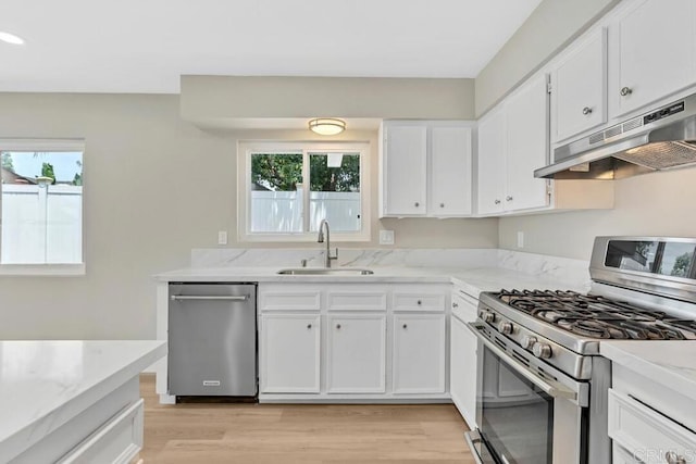 10758 Princess Arlene Dr, Santee, CA 92071 - kitchen with appliances with stainless steel finishes, under cabinet range hood, light wood-style floors, and white cabinets