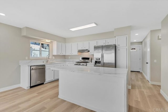 10758 Princess Arlene Dr, Santee, CA 92071 - kitchen featuring appliances with stainless steel finishes, under cabinet range hood, light wood-type flooring, white cabinetry, and recessed lighting