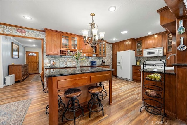 24481 Jutewood Pl, Lake Forest, CA 92630 - kitchen with brown cabinets, ornamental molding, white appliances, tasteful backsplash, and a chandelier