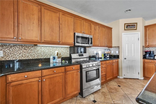 296 Lady Bell Way, Perris, CA 92571 - kitchen with stainless steel appliances, brown cabinets, light tile patterned floors, and backsplash