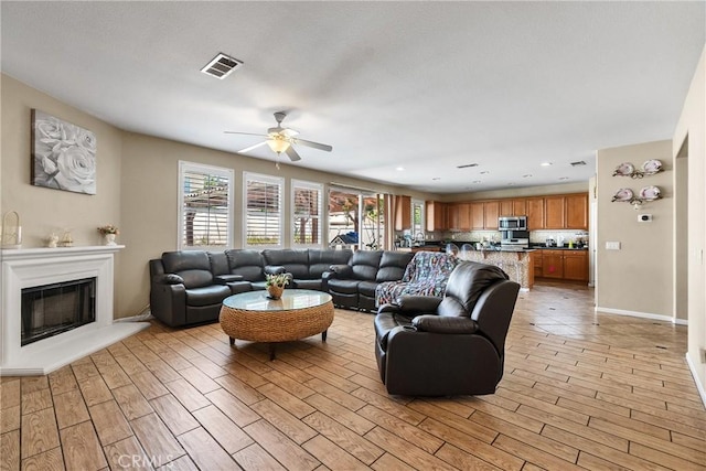 296 Lady Bell Way, Perris, CA 92571 - living room with a ceiling fan, light wood-style flooring, a glass covered fireplace, and recessed lighting