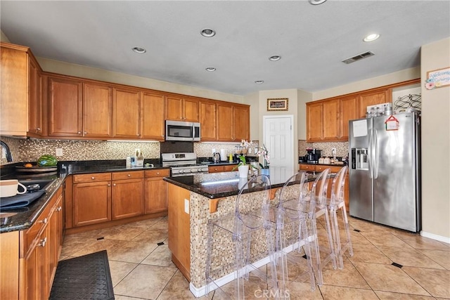 296 Lady Bell Way, Perris, CA 92571 - kitchen featuring stainless steel appliances, brown cabinetry, a kitchen island, a breakfast bar, and recessed lighting