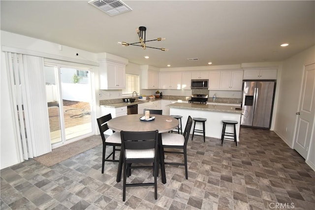 5280 Coyote St, Hemet, CA 92545 - dining room featuring a chandelier, recessed lighting, and stone finish flooring