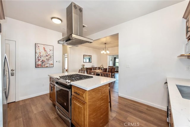 5336 Lemon Grove Ave, Los Angeles, CA 90038 - kitchen with island exhaust hood, appliances with stainless steel finishes, wood finished floors, a breakfast bar area, and a chandelier