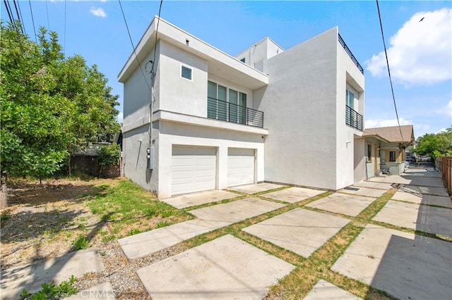 5336 Lemon Grove Ave, Los Angeles, CA 90038 - view of side of home featuring a balcony, stucco siding, and an attached garage