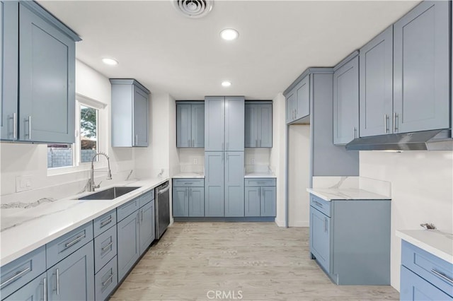 1534 Richfield Ave, Rosamond, CA 93560 - kitchen with light wood-style flooring, under cabinet range hood, recessed lighting, light stone countertops, and dishwasher