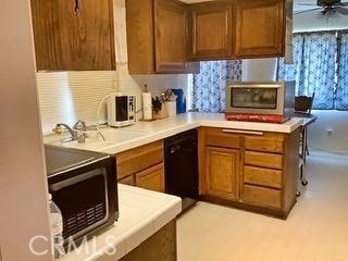 3526 Belle River Dr, Hacienda Heights, CA 91745 - kitchen with light countertops, brown cabinets, tasteful backsplash, black dishwasher, and stainless steel microwave