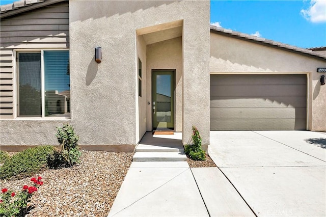 1660 Capri Way, Beaumont, CA 92223 - doorway to property featuring stucco siding, driveway, and an attached garage