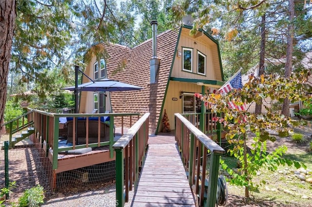 52926 Balsam Dr, Oakhurst, CA 93644 - rear view of property featuring a gambrel roof, a wooden deck, and roof with shingles