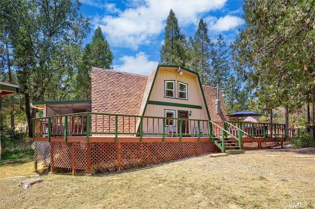 52926 Balsam Dr, Oakhurst, CA 93644 - back of house with a gambrel roof, a deck, and a lawn