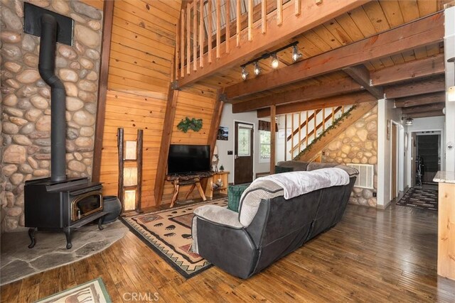 52926 Balsam Dr, Oakhurst, CA 93644 - living area with a wood stove, dark wood-type flooring, stairs, beam ceiling, and rail lighting