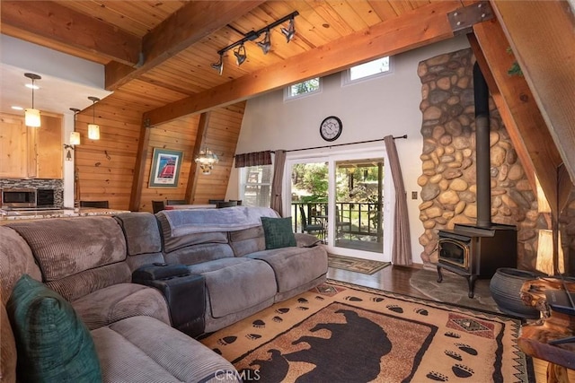 52926 Balsam Dr, Oakhurst, CA 93644 - living area featuring a wooden ceiling with exposed beams, a wood stove, wood walls, plenty of natural light, and wood finished floors