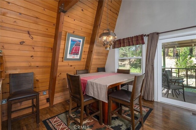 52926 Balsam Dr, Oakhurst, CA 93644 - dining area with dark wood finished floors, wood walls, and a chandelier