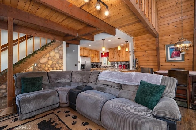 52926 Balsam Dr, Oakhurst, CA 93644 - living area with wood finished floors, a wood ceiling with exposed beams, a chandelier, wooden walls, and stairs