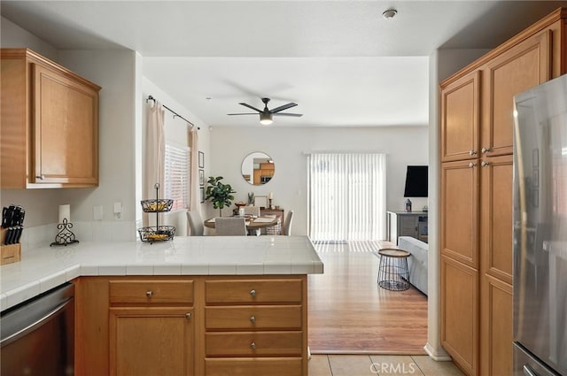 8554 Burnet Ave Unit 144, North Hills, CA 91343 - kitchen with ceiling fan, a peninsula, appliances with stainless steel finishes, and light tile patterned floors