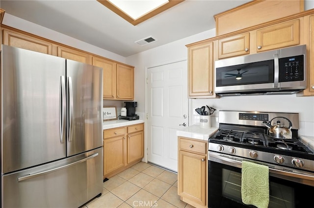 8554 Burnet Ave Unit 144, North Hills, CA 91343 - kitchen with stainless steel appliances, tile countertops, light tile patterned flooring, and light brown cabinetry