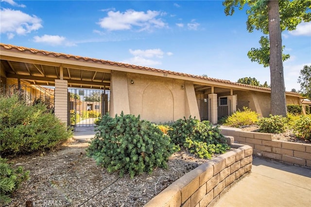 939 W Pine St Unit 44/D, Upland, CA 91786 - view of front of property featuring stucco siding and a gate