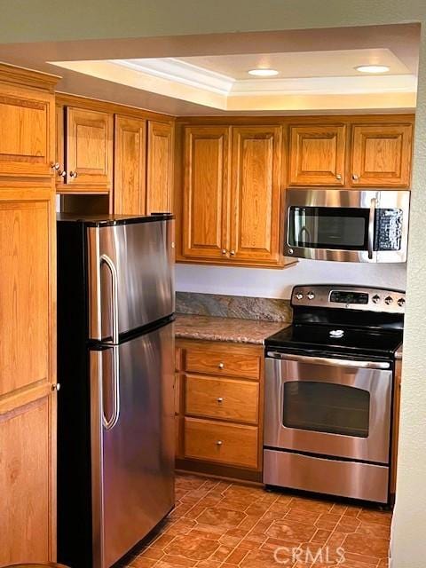 13212 La Jolla Cir Unit 307B, La Mirada, CA 90638 - kitchen featuring appliances with stainless steel finishes, a raised ceiling, brown cabinetry, and recessed lighting