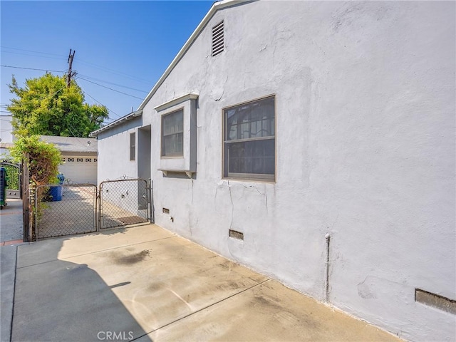10348 Woodbridge St, Toluca Lake, CA 91602 - view of home's exterior featuring crawl space, a gate, and stucco siding