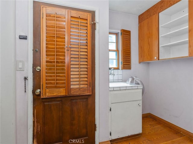 10348 Woodbridge St, Toluca Lake, CA 91602 - laundry area featuring wood finished floors and baseboards