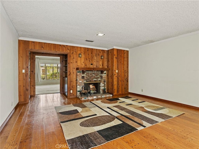 10348 Woodbridge St, Toluca Lake, CA 91602 - unfurnished living room with ornamental molding, wood-type flooring, wood walls, a textured ceiling, and a fireplace