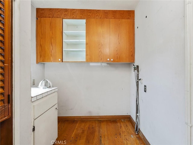 10348 Woodbridge St, Toluca Lake, CA 91602 - laundry room featuring wood finished floors and baseboards
