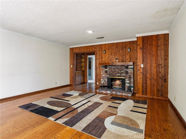 10348 Woodbridge St, Toluca Lake, CA 91602 - living area with crown molding, wood finished floors, wooden walls, a textured ceiling, and a fireplace