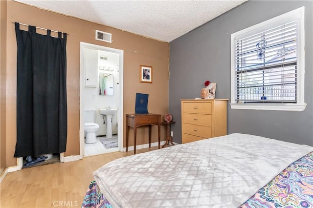 16533 Nordhoff St, North Hills, CA 91343 - bedroom featuring light wood-style floors, a textured ceiling, and connected bathroom