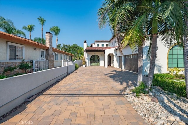 6204 Oak Ave, Temple City, CA 91780 - mediterranean / spanish house with stucco siding, an attached garage, decorative driveway, and a chimney