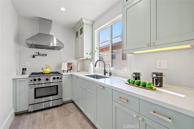 6204 Oak Ave, Temple City, CA 91780 - kitchen with high end stainless steel range, wall chimney range hood, light countertops, decorative backsplash, and light wood-style floors