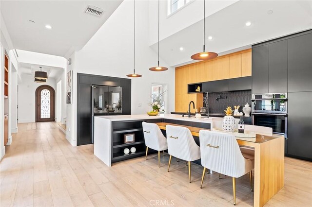 6204 Oak Ave, Temple City, CA 91780 - kitchen with a high ceiling, modern cabinets, a center island with sink, open shelves, and plenty of natural light