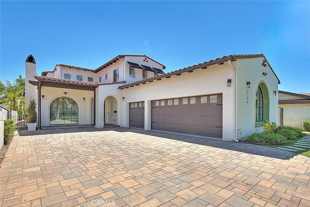 6204 Oak Ave, Temple City, CA 91780 - mediterranean / spanish-style house featuring stucco siding, decorative driveway, a garage, a tiled roof, and a chimney