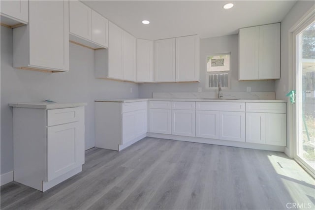 460 E 2nd St, San Jacinto, CA 92583 - kitchen with light wood-style floors, white cabinets, recessed lighting, and light countertops