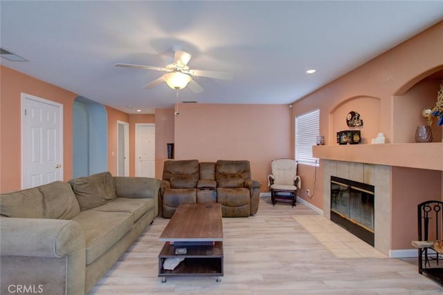 1166 Labrador Ct, Newman, CA 95360 - living area featuring a ceiling fan, a tile fireplace, light wood finished floors, arched walkways, and recessed lighting