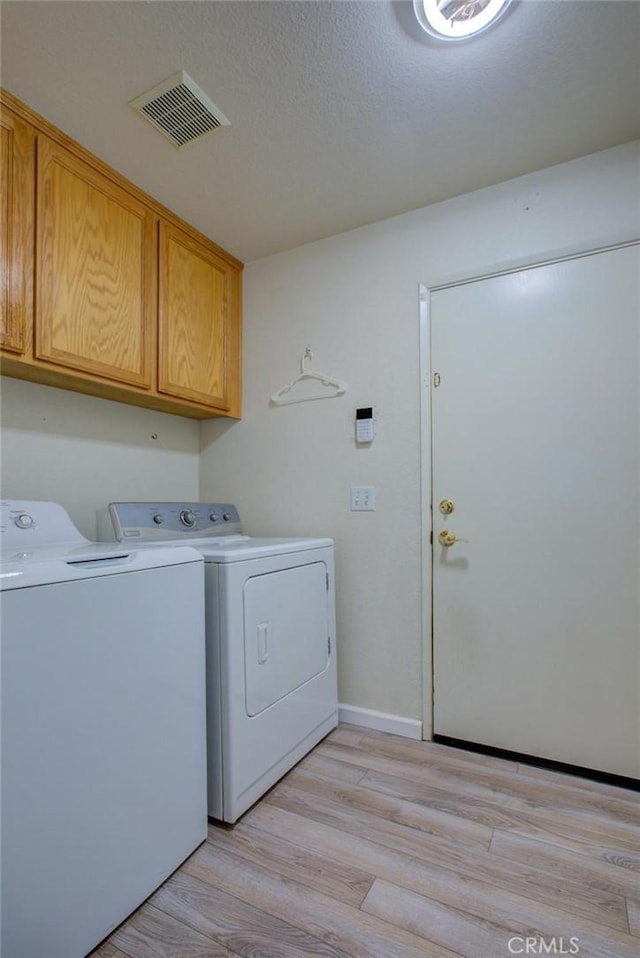 1166 Labrador Ct, Newman, CA 95360 - laundry room featuring washing machine and dryer, cabinet space, and light wood finished floors